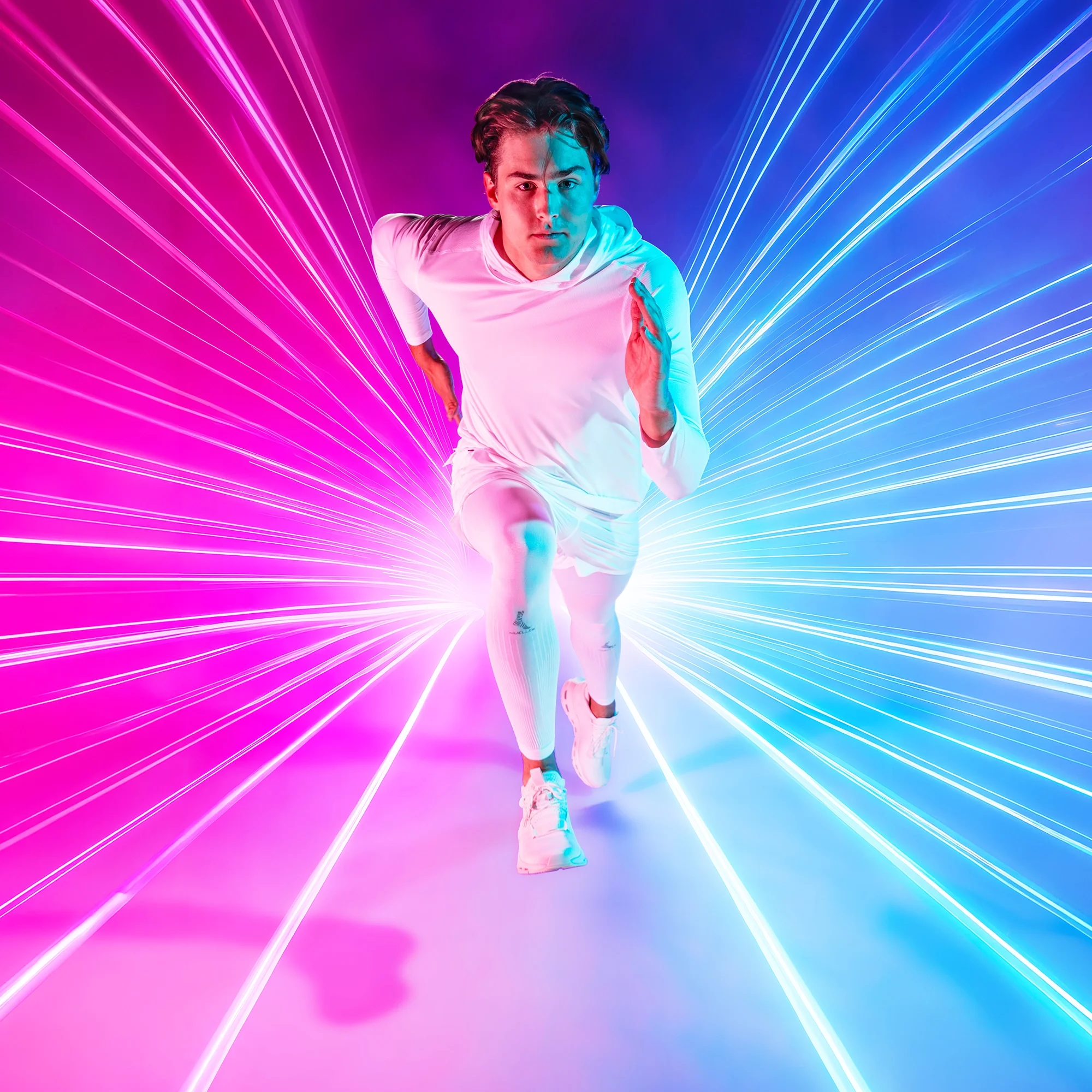 A young man in a white sports shirt and shorts running forward against a vibrant background of pink and blue neon light streaks.
