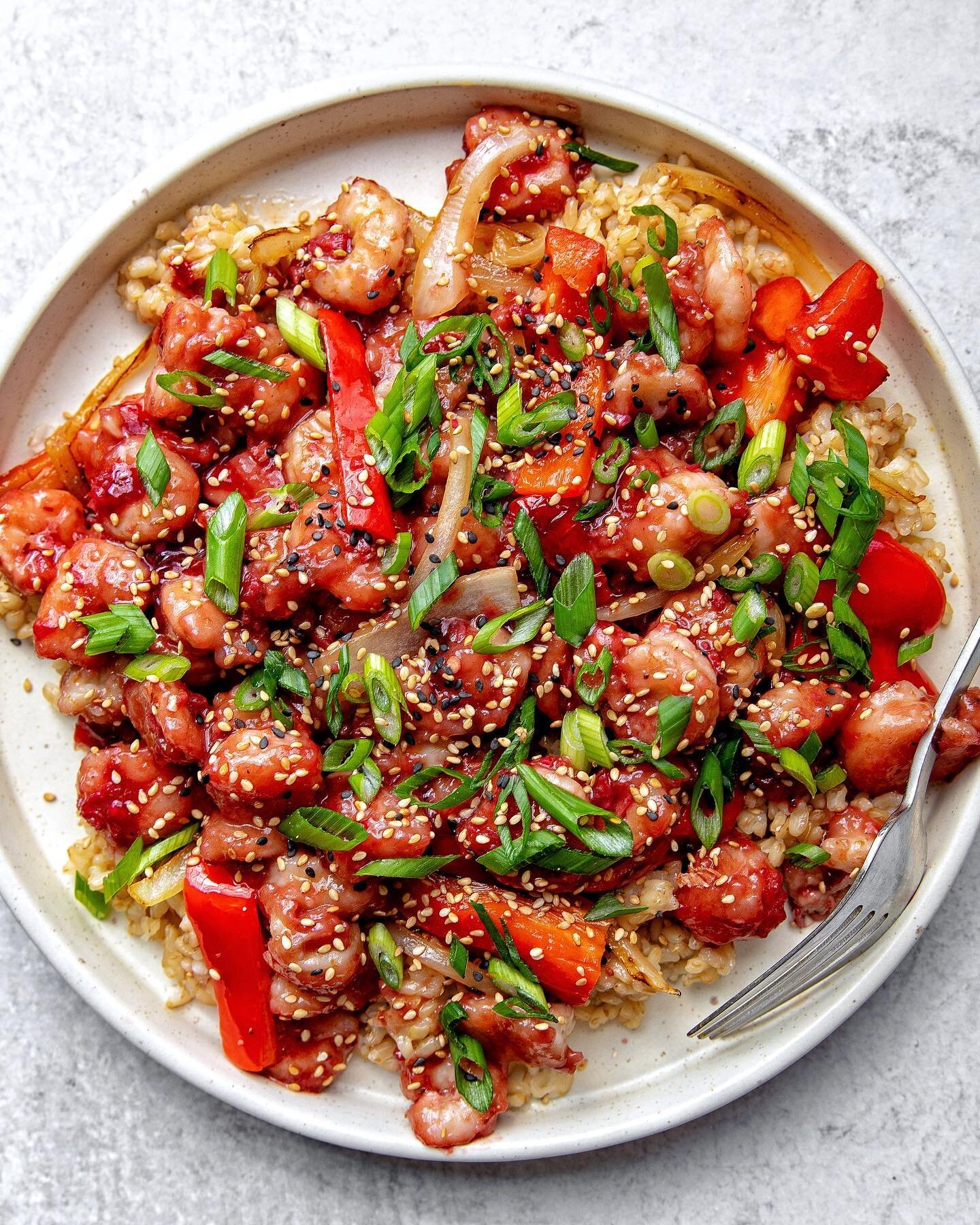 Blood Orange Shrimp with sautéed red pepper and onion, brown rice, scallions, and sesame seeds!

This recipe is the same as my blood orange chicken recipe &mdash; just with shrimp! Both are inspired by Chinese-American orange chicken and the more tr