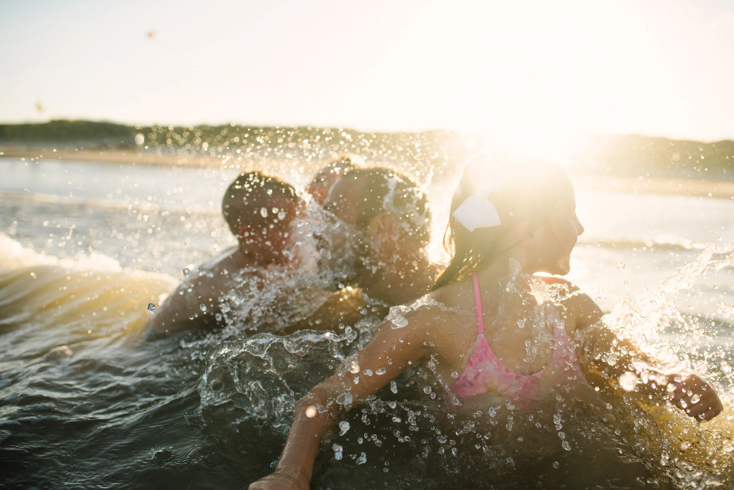 Family playing in the waves on Mustang Island near Port Aransas by South Texas Award Winning Family Photographer Mae Burke serving Rockport, Port Aransas, Corpus Christi, and Fort Worth