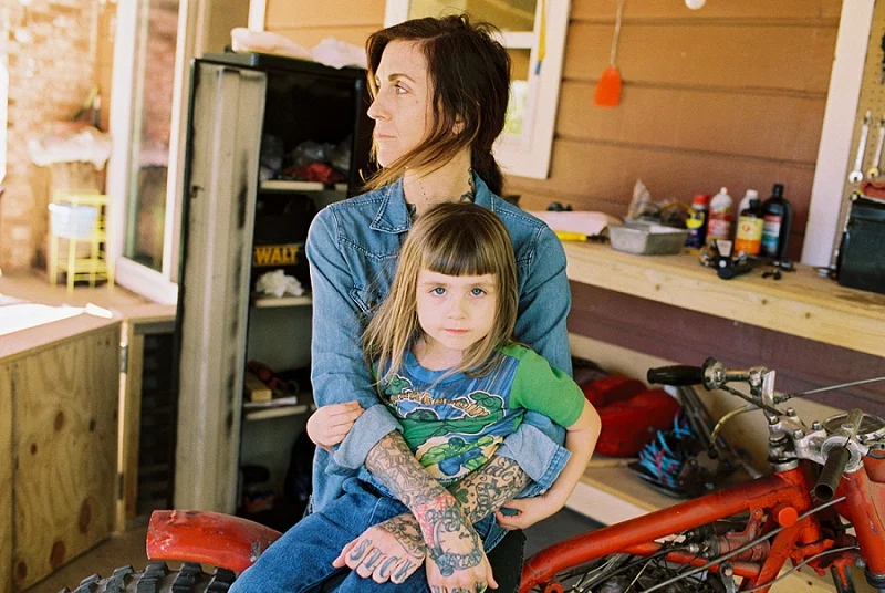  Film image of mother sitting on motorcycle with daughter in her lap by award winning Maternity, Baby, and Family Photographer, Mae Burke- Photographing families in and visiting Rockport, Port Aransas, Corpus Christi, Austin, Houston and Dallas/Fort 