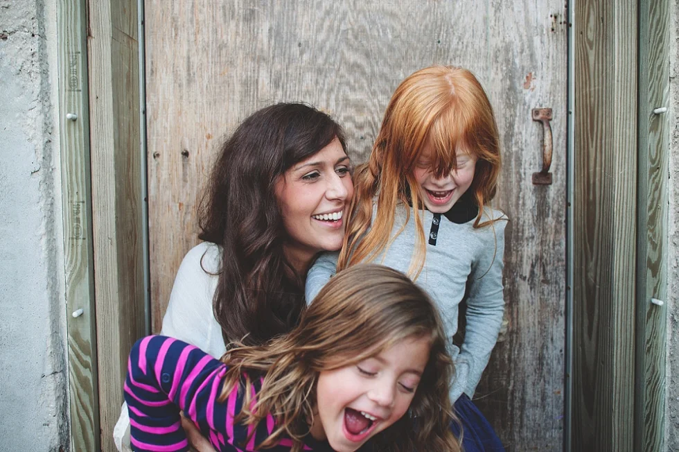  Mother and laughing with two daughters during an on-location family session with award winning Maternity, Baby, and Family Photographer, Mae Burke- Photographing families in and visiting Rockport, Port Aransas, Corpus Christi, Austin, Houston and Da