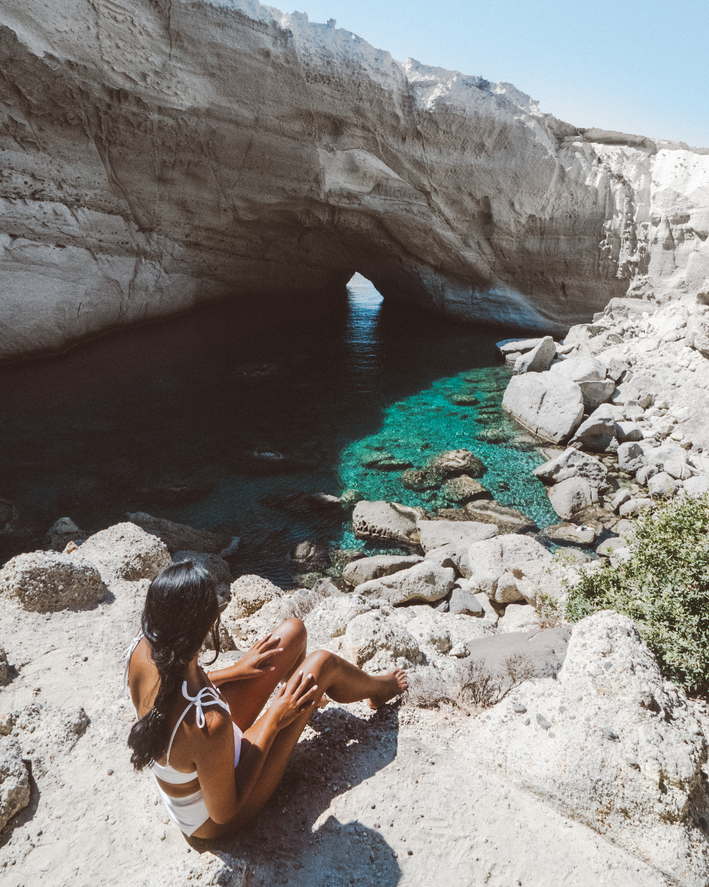 Milos的Sykia sea Cave, Mel穿着白色比基尼坐在海边-旅游指南