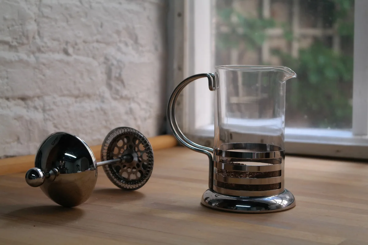 Grind 26g of coffee beans set fairly course resembling gritty sand. Place the coffee into the pot.