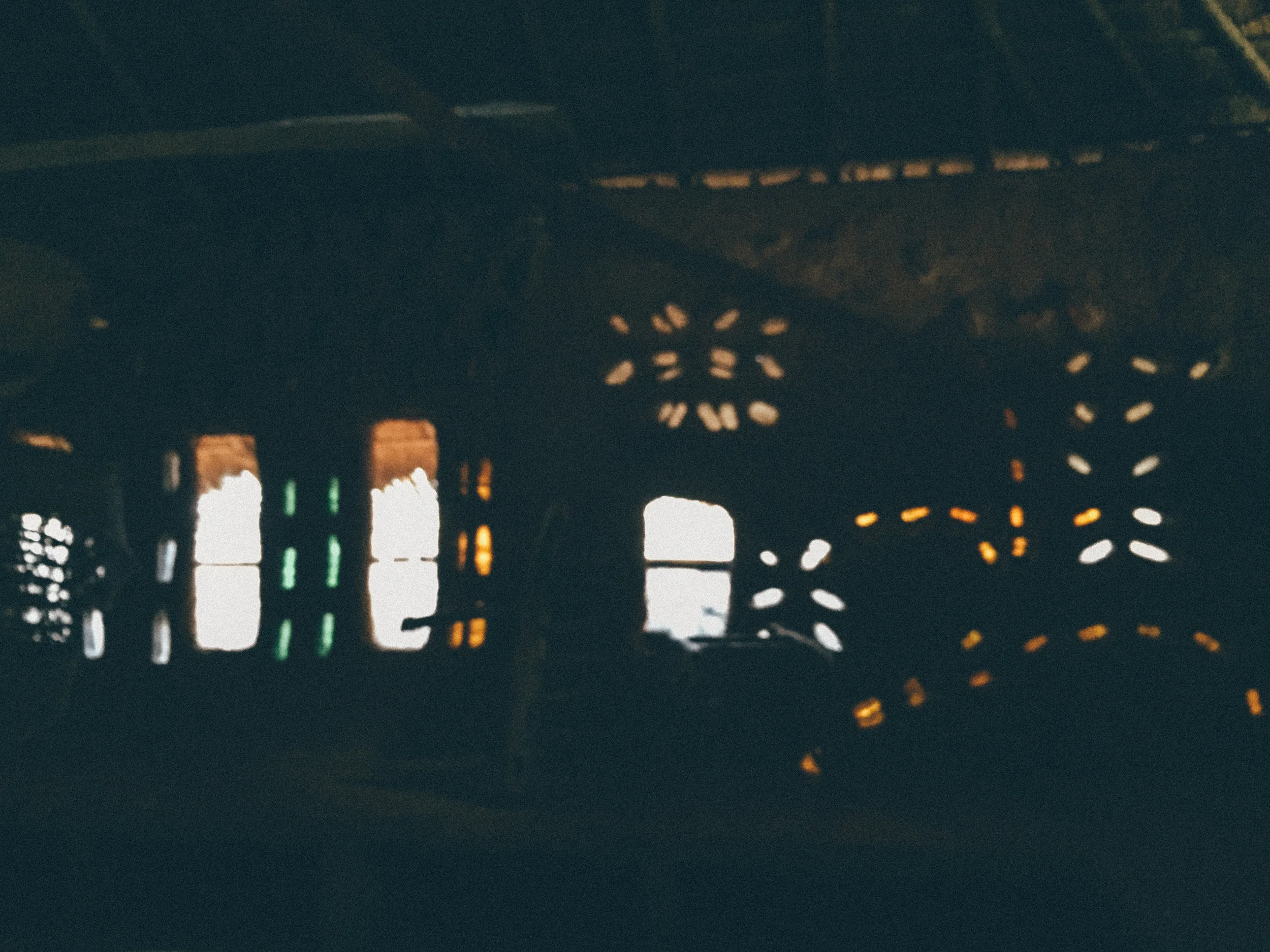 Inside the mud house, with glass bottles filtering soft light into the cool dark space