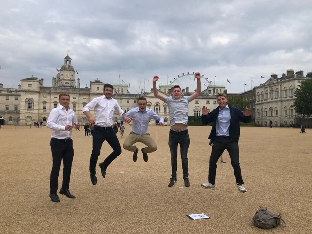 Team all in mid air outside buckingham palace