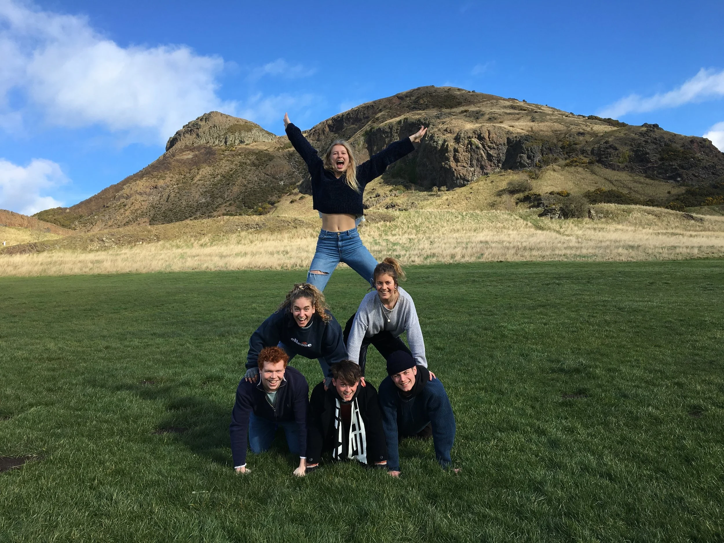 Challenge: Photo of team creating a human pyramid in front of Arthur's Seat