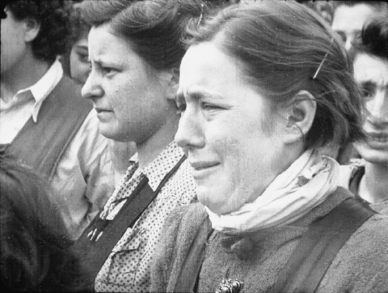 A distressed young woman watches a burial at Belsen. Sergeant &nbsp;Lewis, 17 April 1945. © Imperial War Museums (FLM 1002).