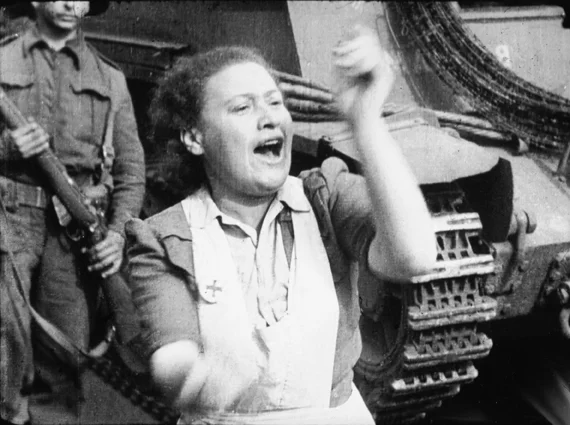‘Ex-prisoner claps her approval of the strictness shown by Tommies.’ Still from footage shot by Sergeant Lewis, 16 April 1945. © Imperial War Museums (FLM 1001).