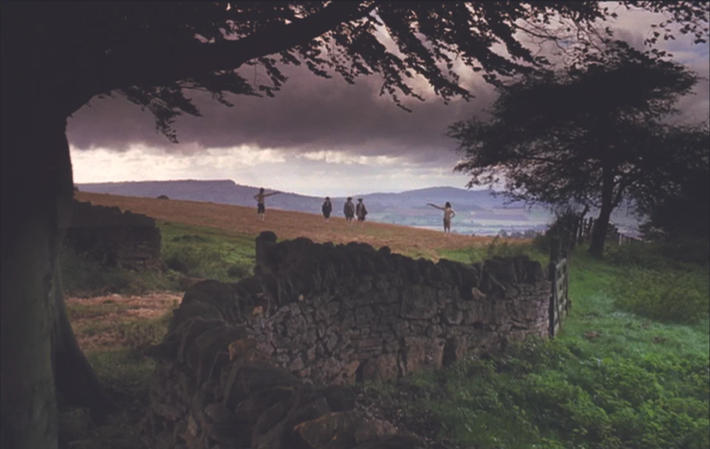 The father of Redmond Barry engages in a duel at the start of the film, framed by mountains and a crumbling stone wall.