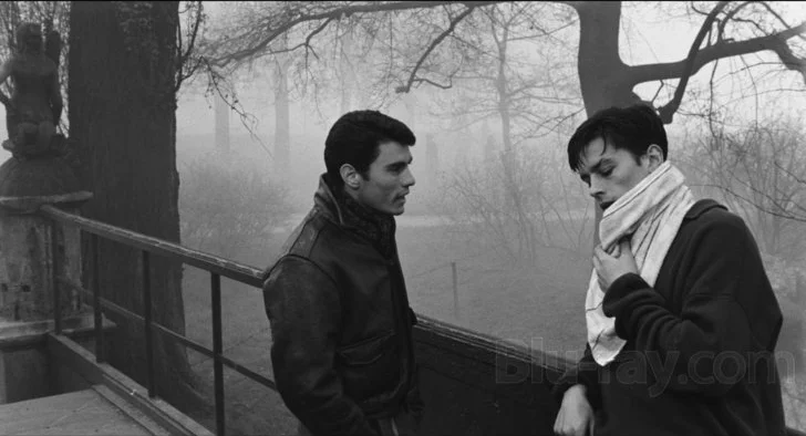Rocco (Alain Delon) speaks with his brother Vincenzo (Spiros Focás).