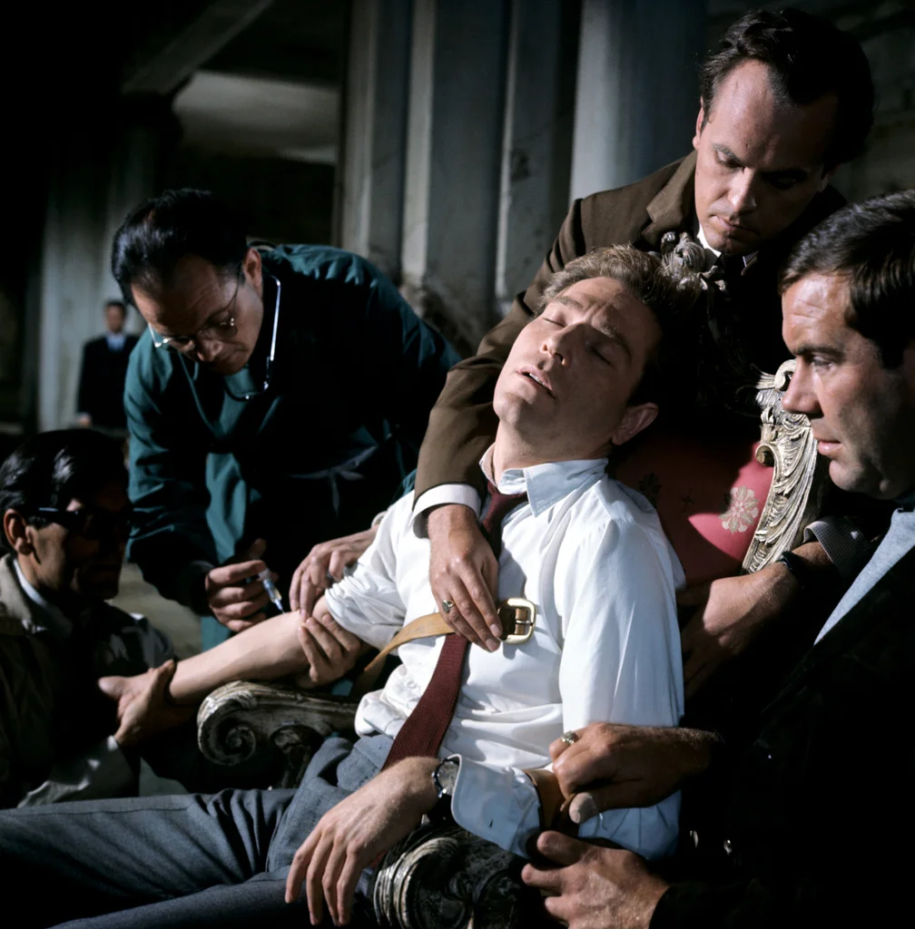 Quiller being injected with truth serum by agents of Phoenix.
