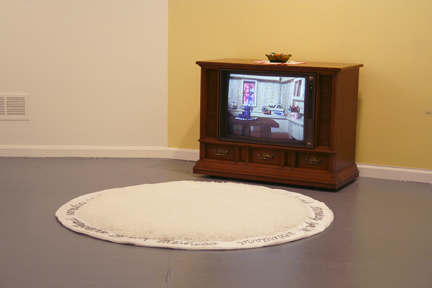   I Don't Love You Anymore,  2007, console television, shag rug with hand embroidered "someday you'll understand", satin fabric, ribbon candy, candy dish, dvd: 2.39 minutes 