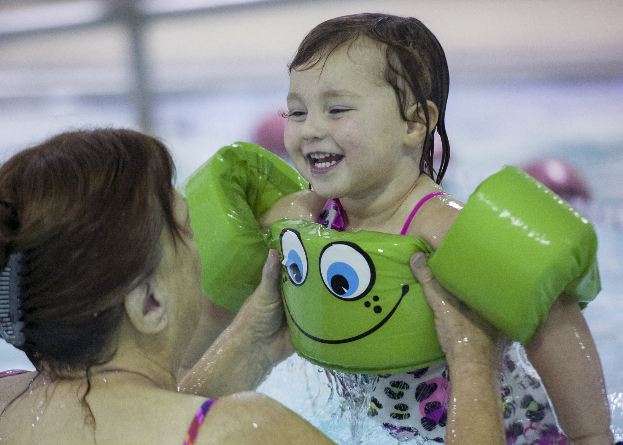 Teacher Chris McLain lifts Emily Stack out of the pool. The class goes to the pool and swims every Monday, Wednesday and Friday.