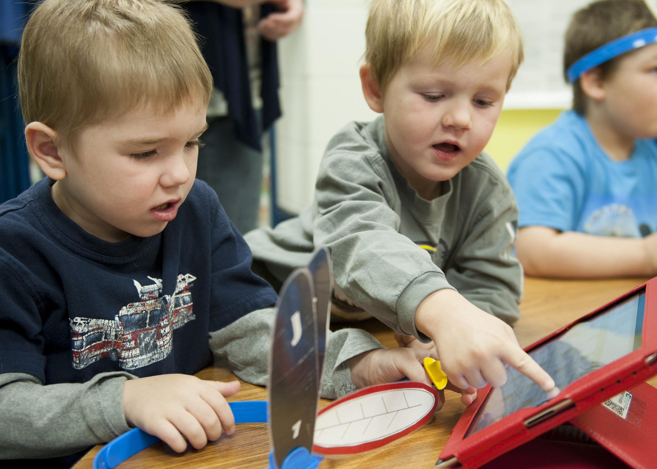 Braven Windle looks on as Ronnie Riley clicks on a student's picture on the IPad that was being passed around the classroom.