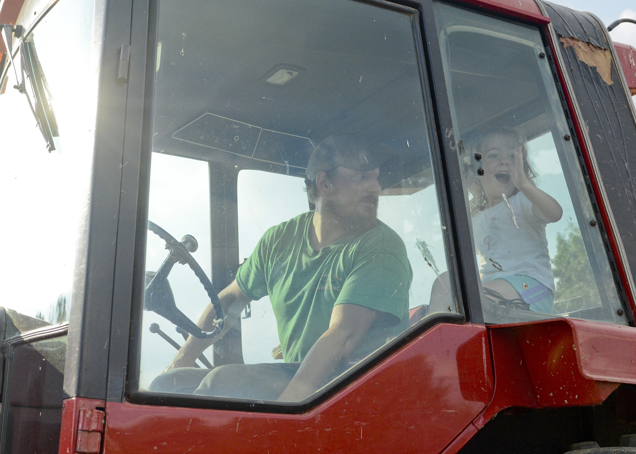  Lee Gauker of Fleetwood looks on while his daughter Callie, 2 1/2, waves goodbye to her mom in his tractor before riding around the fields at one of the Gauker Family's properties in Fleetwood. 