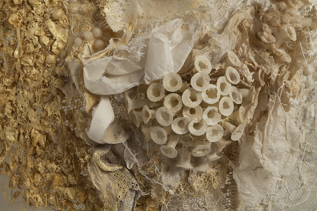   Hybrid (gold),  2017, handmade paper, found objects: cocoons, hairnets, gold pigment, rawhide bones, wire armature, 60” x 120”      