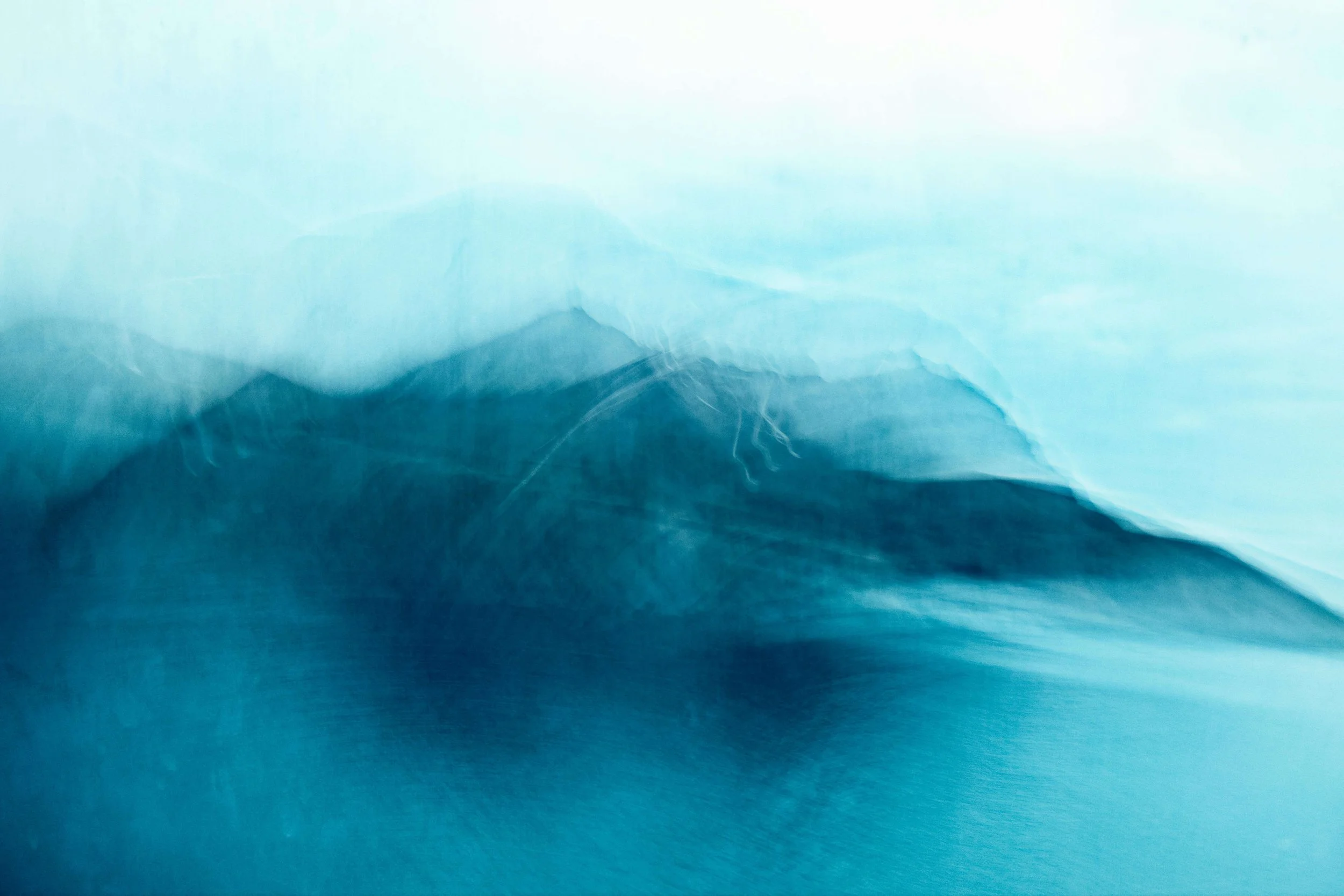A blurry blue and white photograph of a mountain range