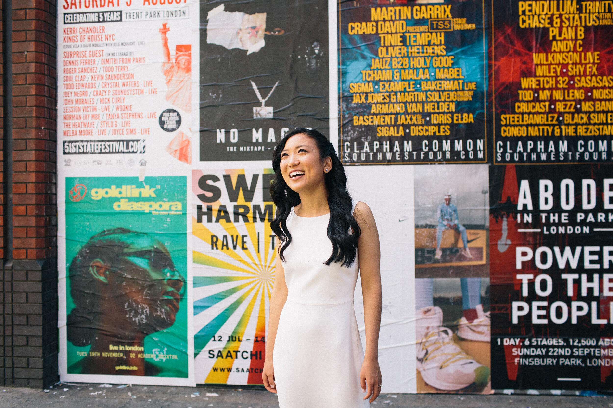 Bride in wedding dress standing in front of coloured wall