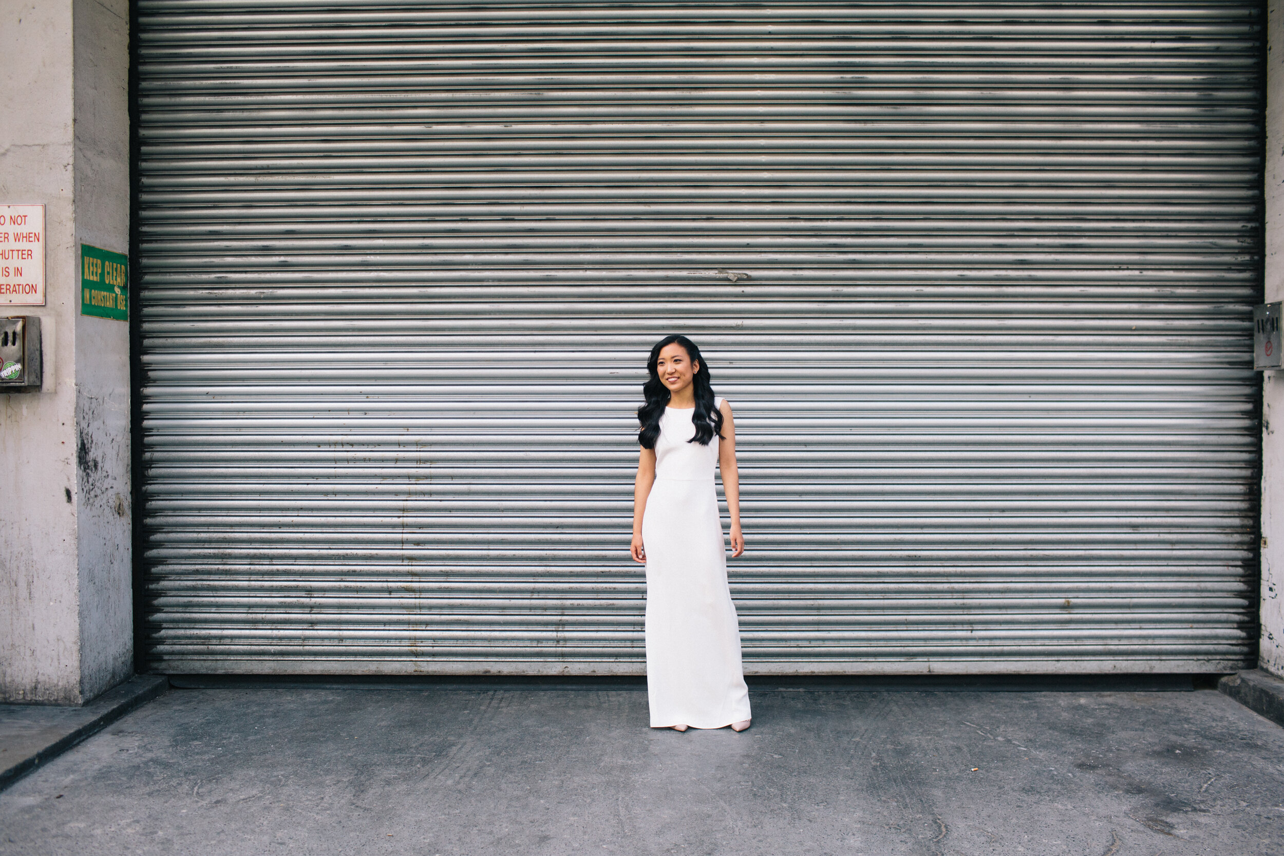 Bride standing in front of metal shutters in Soho