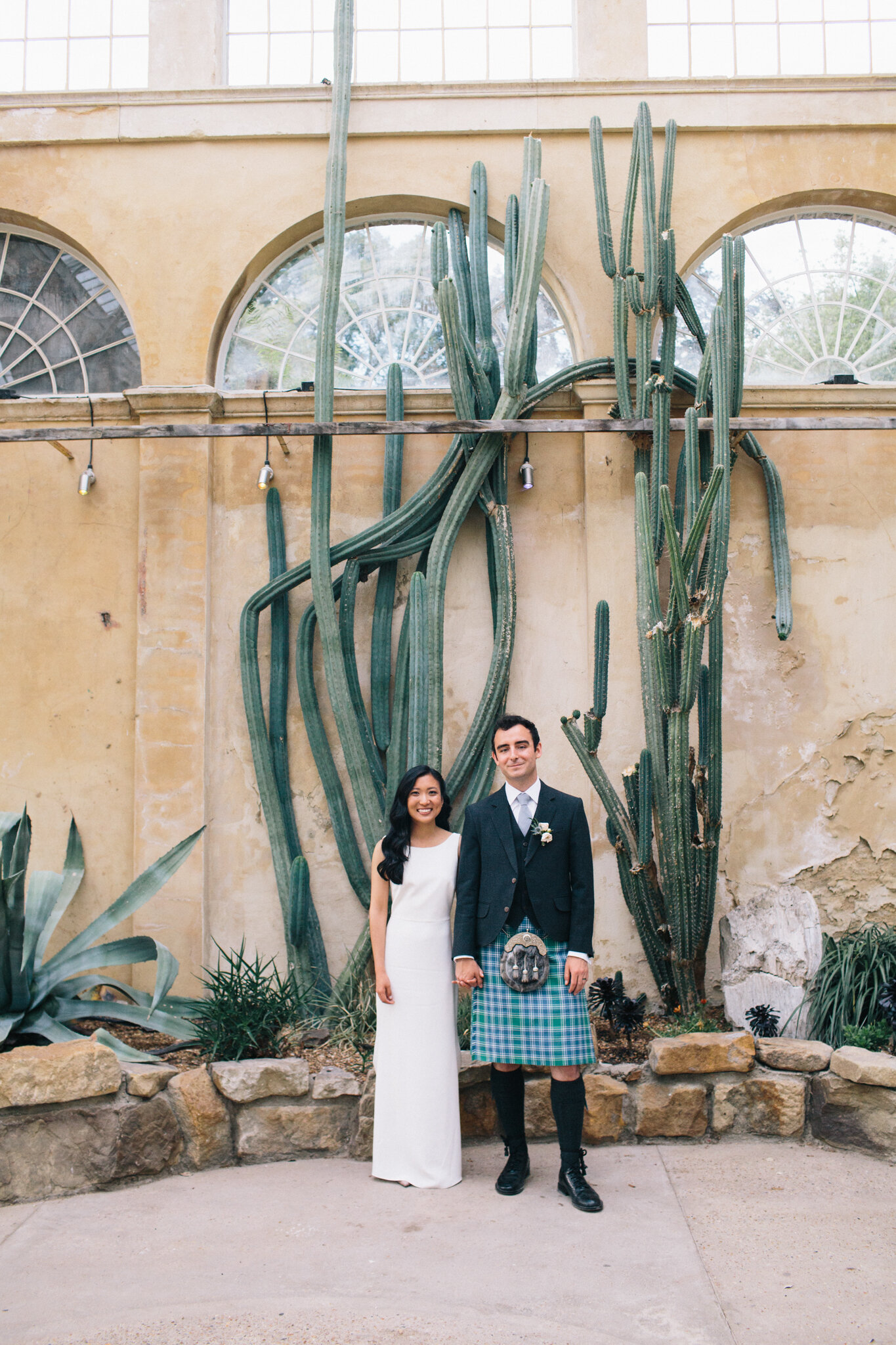 Bride and groom in cactus conservatory at Syon Park Wedding