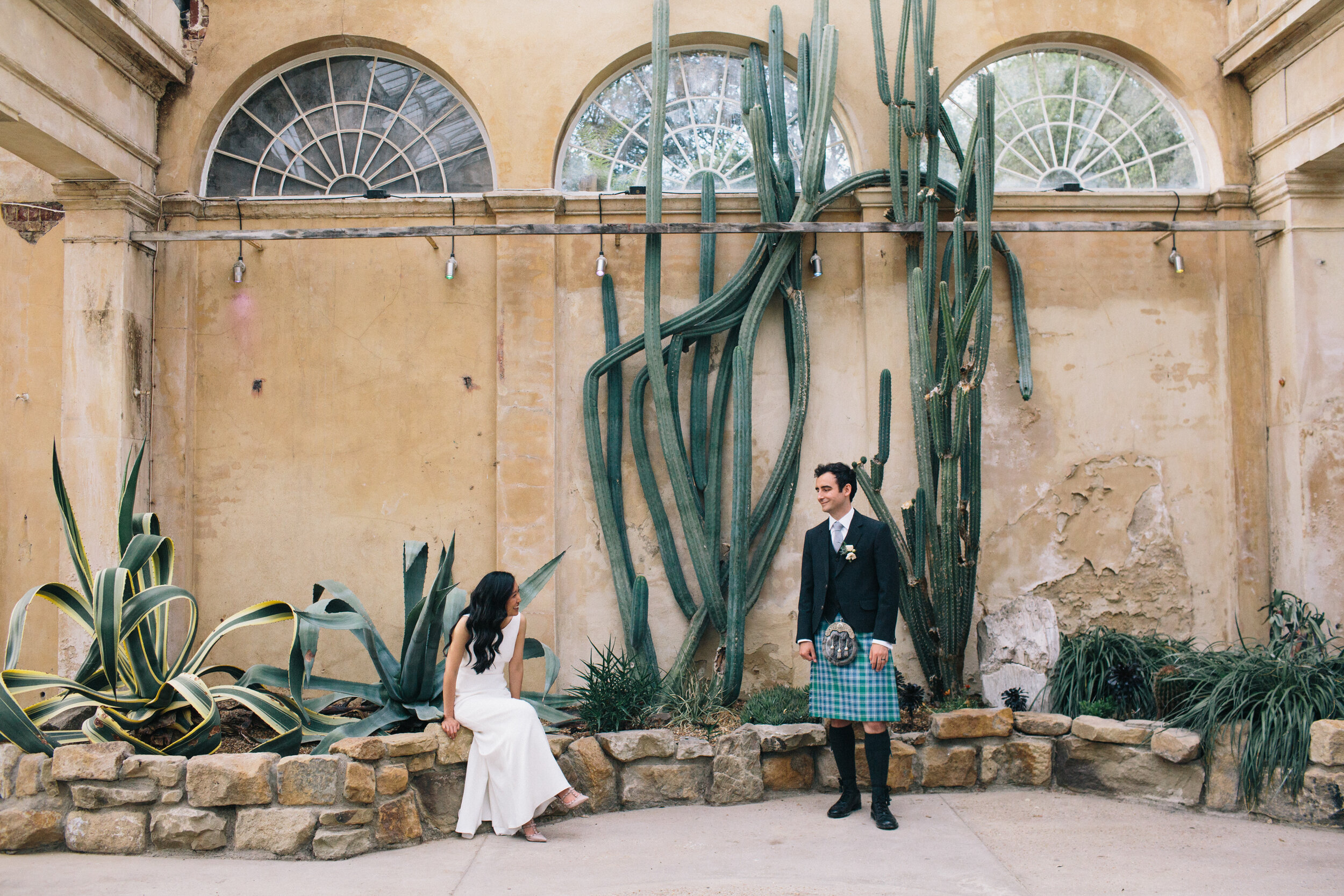 Bride and groom in cactus conservatory at Syon Park Wedding