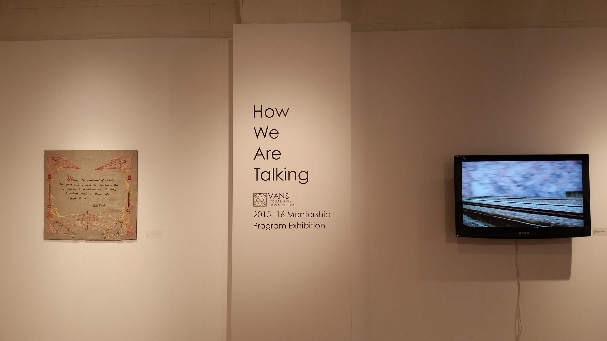 Left: Anna Taylor, Moral Code (cotton thread on linen, 26″ x 24″) and right, Becka Barker, Place Holder II: 110/300 km/hr (digital video, 1920x1080). Installation shot from How We Are Talking, VANS 2015-2016 Mentorship Program Exhibition.