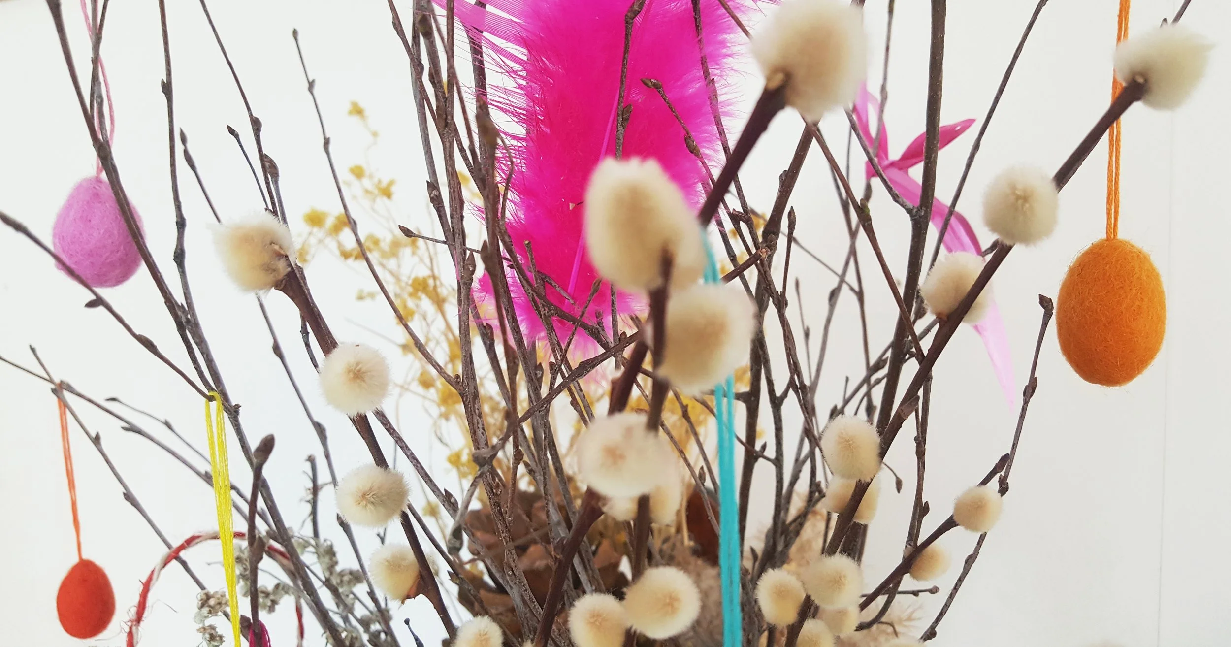 Påskriset prytt av allehanda: en knallig fjäder från min samling av rosa fjädrar som jag funnit hipp som happ, skinande dansk peng & skärt presentsnöre, fjolårets torkade gulblomster & exotiska små tussar till ägg,
