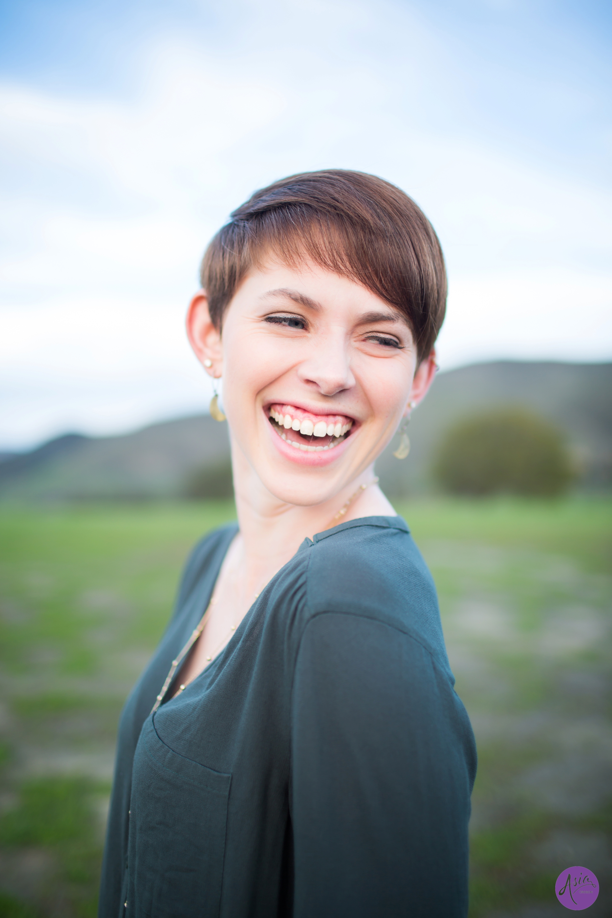 Girl with short hair smiling over her shoulder