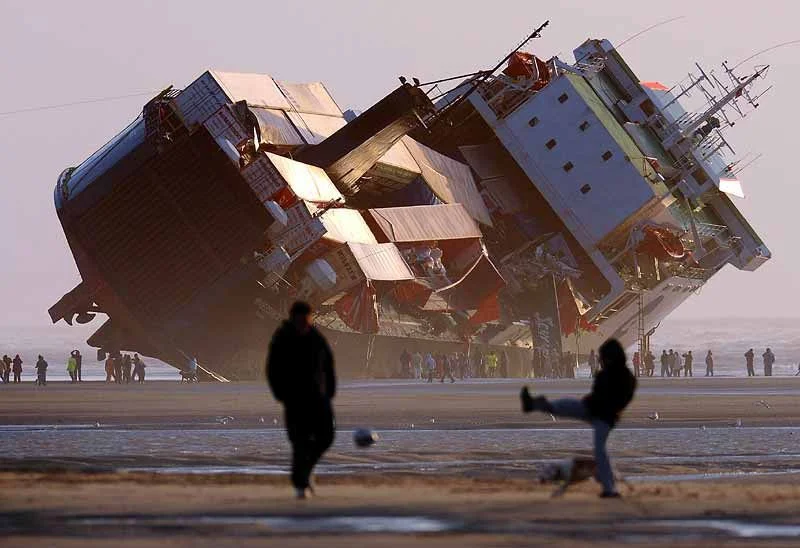 Shipping vessel with containers, grounded & inoperable.