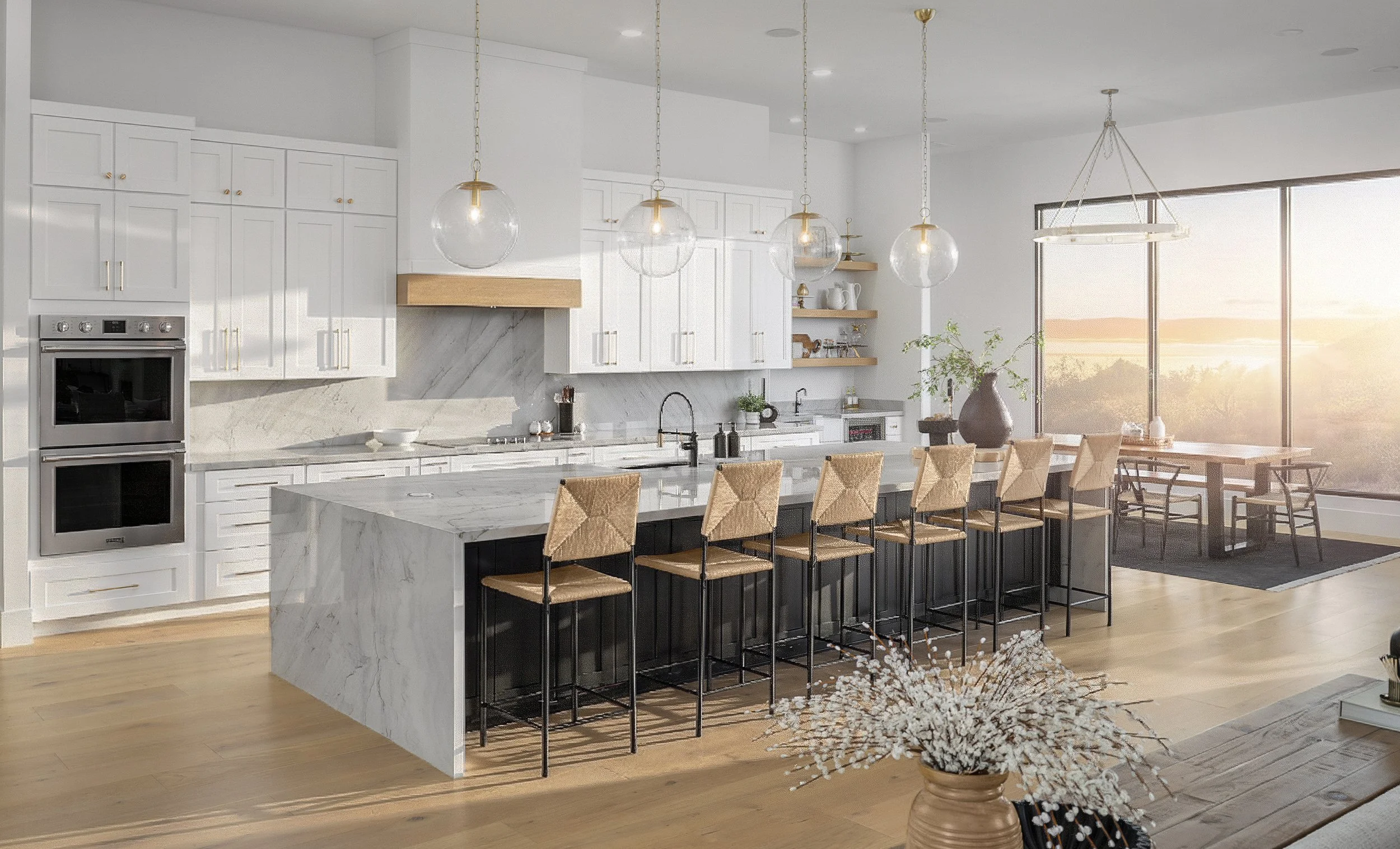 Modern open-concept kitchen with white cabinetry, a marble island, and a breakfast bar with high stools. Sunlight streams through large windows, illuminating the space decorated with pendant lights, plants, and wooden accents.