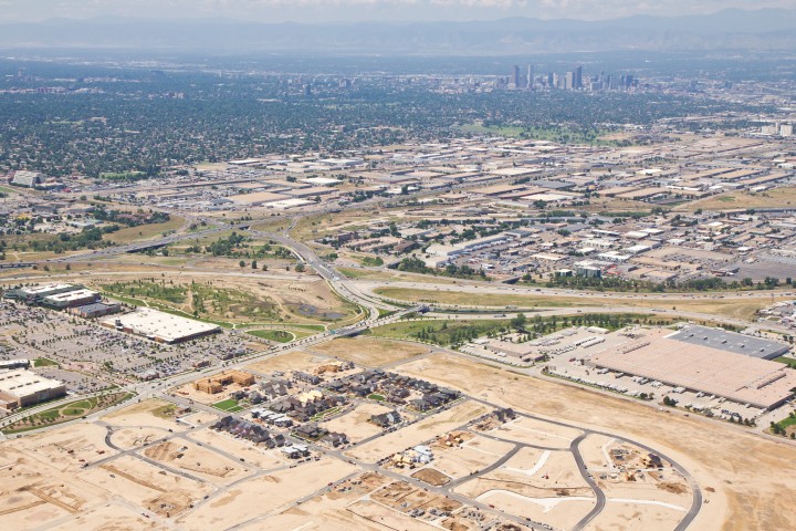 Conservatory Green under construction, with Northfield across the street to the left and Downtown Denver and the mountains in the background.