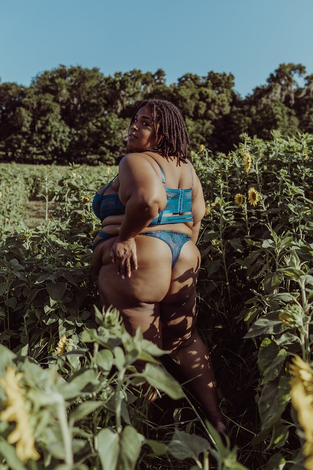  beautiful black woman shows off her assets in a blue outfit while outside with her boudoir photographer 