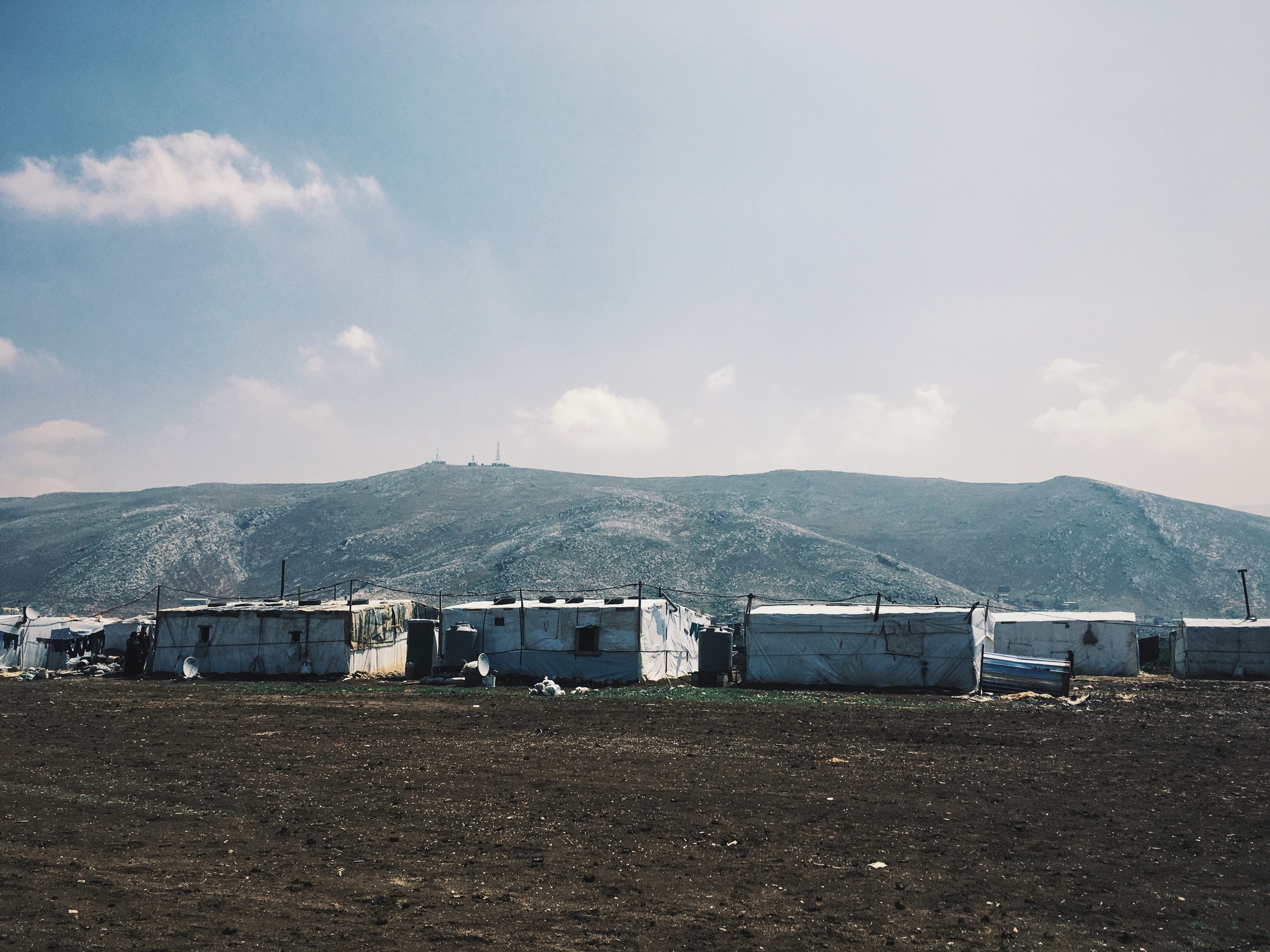 The mountains of Syria form a backdrop to the 'no mans land' of an Informal tent settlement in the Beqaa Valley, Lebanon, March 2016. 