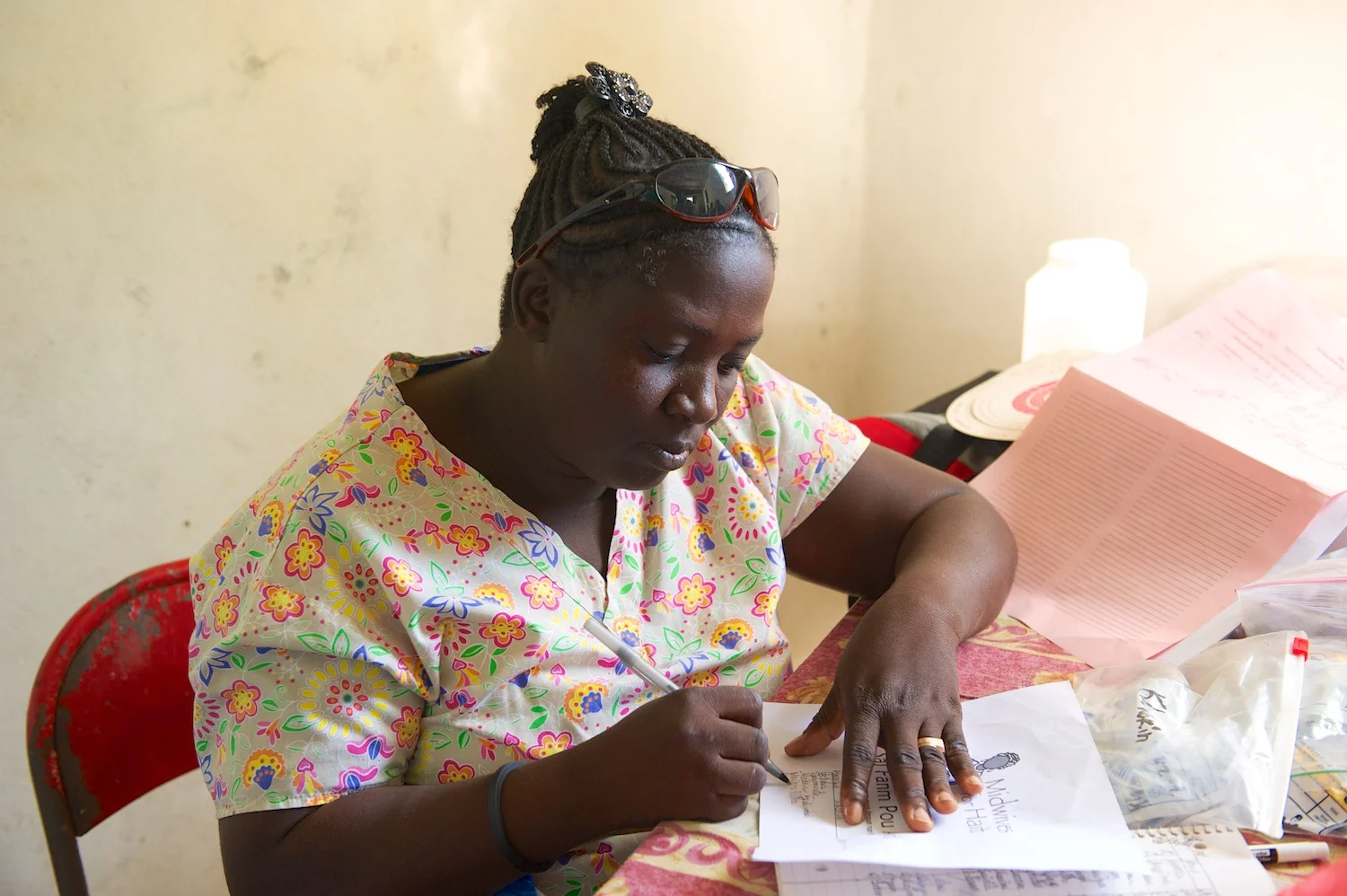 Magdala, a beloved graduate of Midwives for Haiti, attends to charting while working in a rural prenatal clinic.