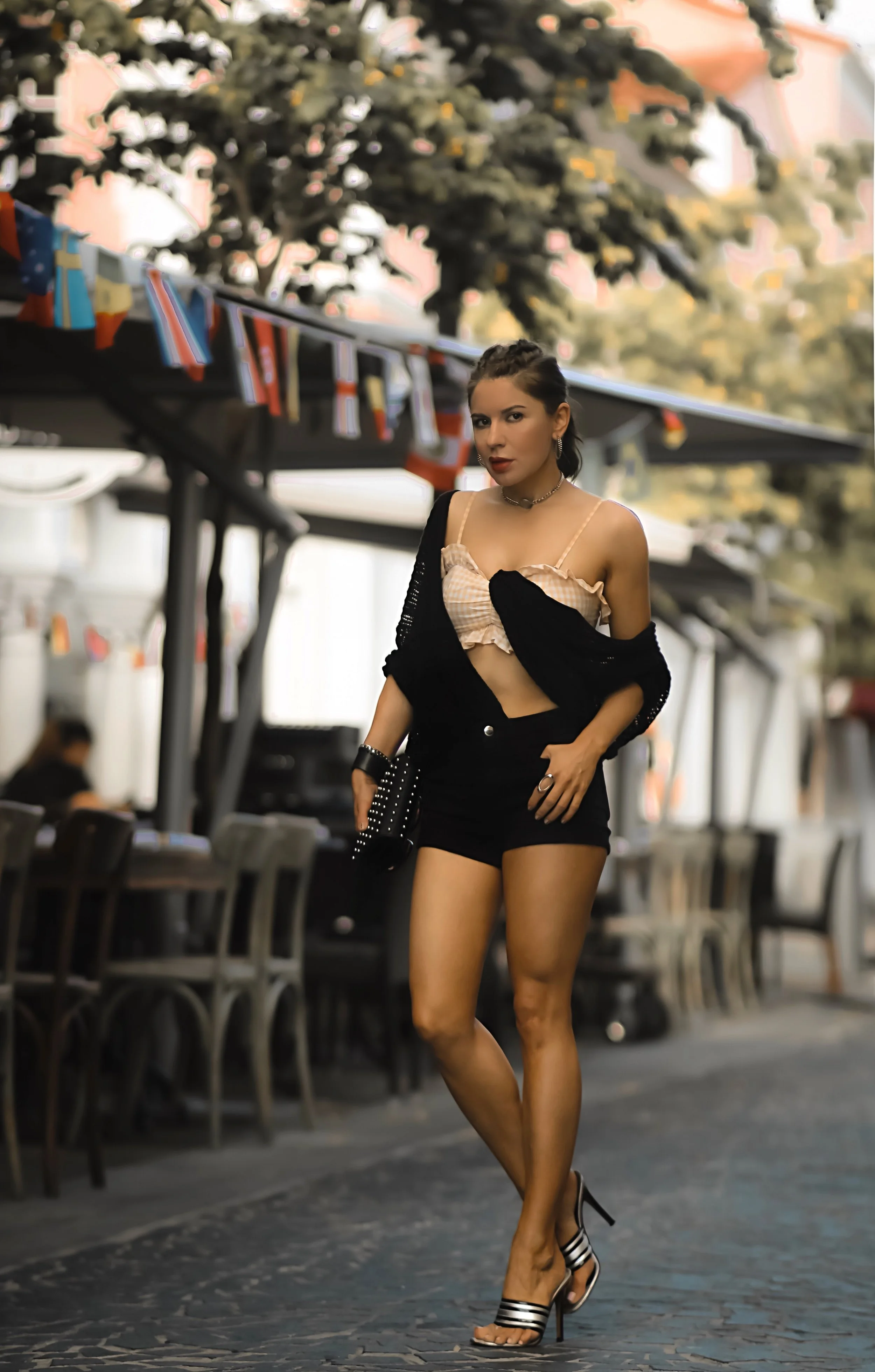 Isabel Alexander wearing black denim shorts with crop top and open knit cardigan