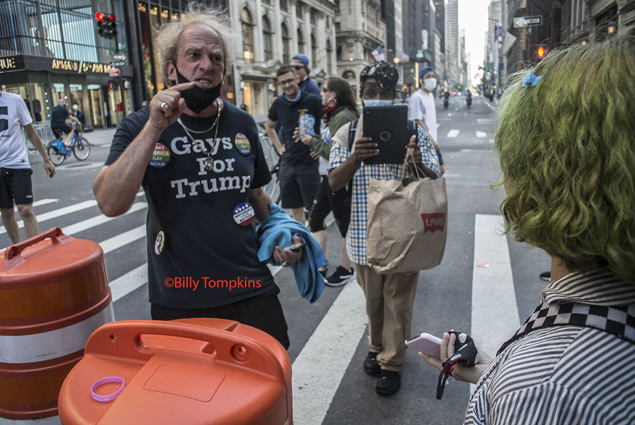  Man wearing shirt that says ‘ GAYS FOR TRUMP’  screaming at a young gay woman.  New York City / 2020 