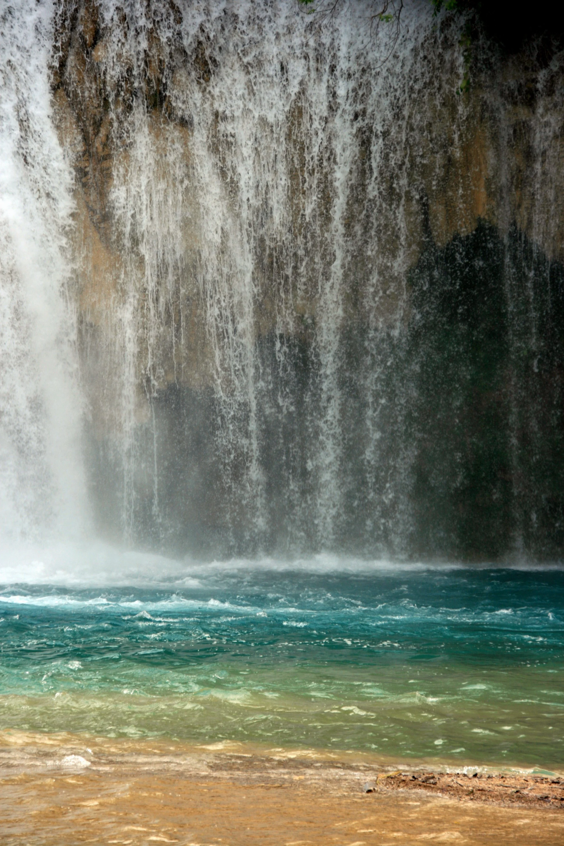 Cascade d'eau tombant d'une falaise rocheuse dans une rivière.