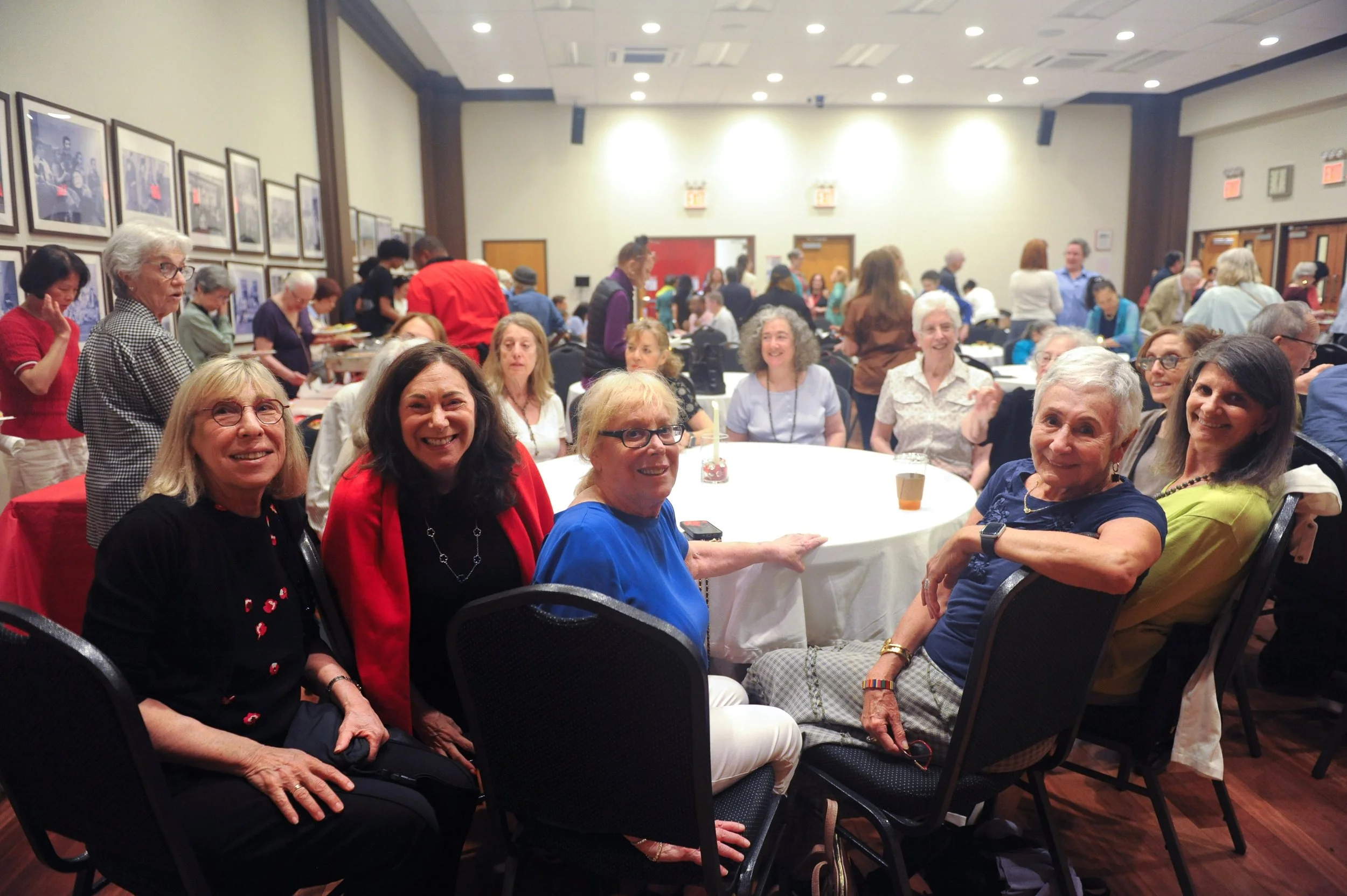 photo of a group of volunteers smiling at camera in a crowded auditorium