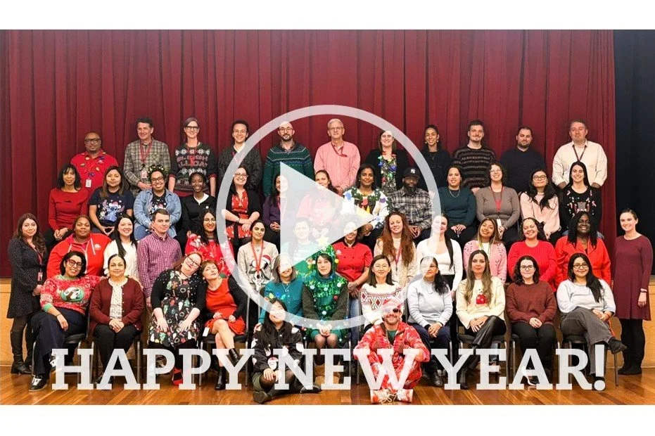 photo of group of people dressed in red and green with text reading "HAPPY NEW YEAR!"