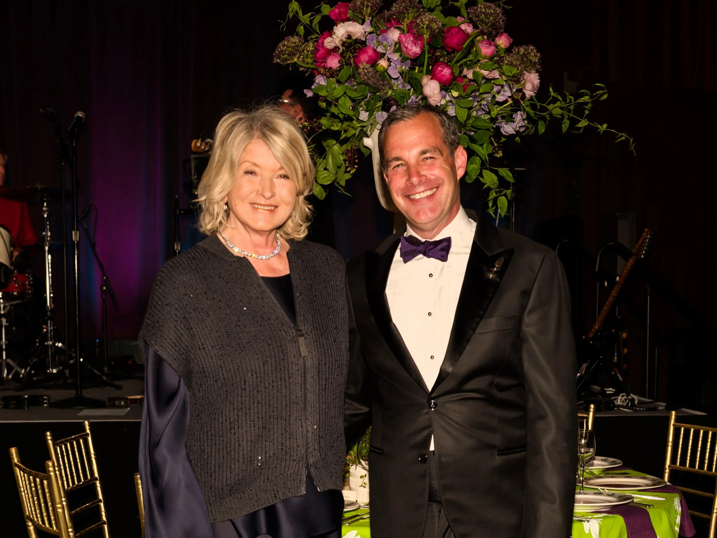 Martha Stewart & Christopher Spitzmiller posing in front of tall floral arrangement