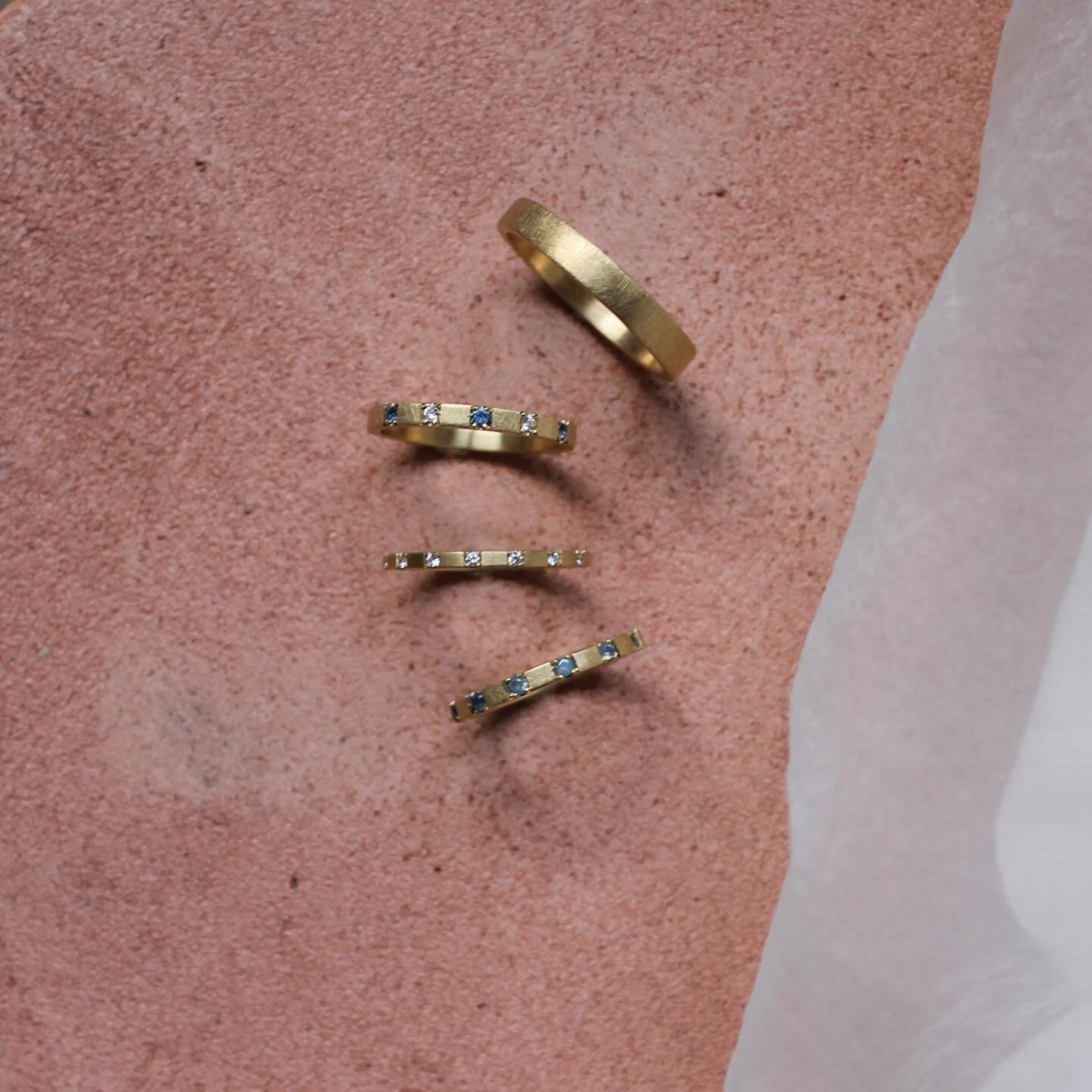 Lines that link us - Lines of Latitude Wedding and Eternity Rings. Shown here: the Lines of Latitude Eternity Ring I and II, and a bespoke version of Eternity ring II set with four sapphires and three diamonds. Completing the set is the timeless Lati