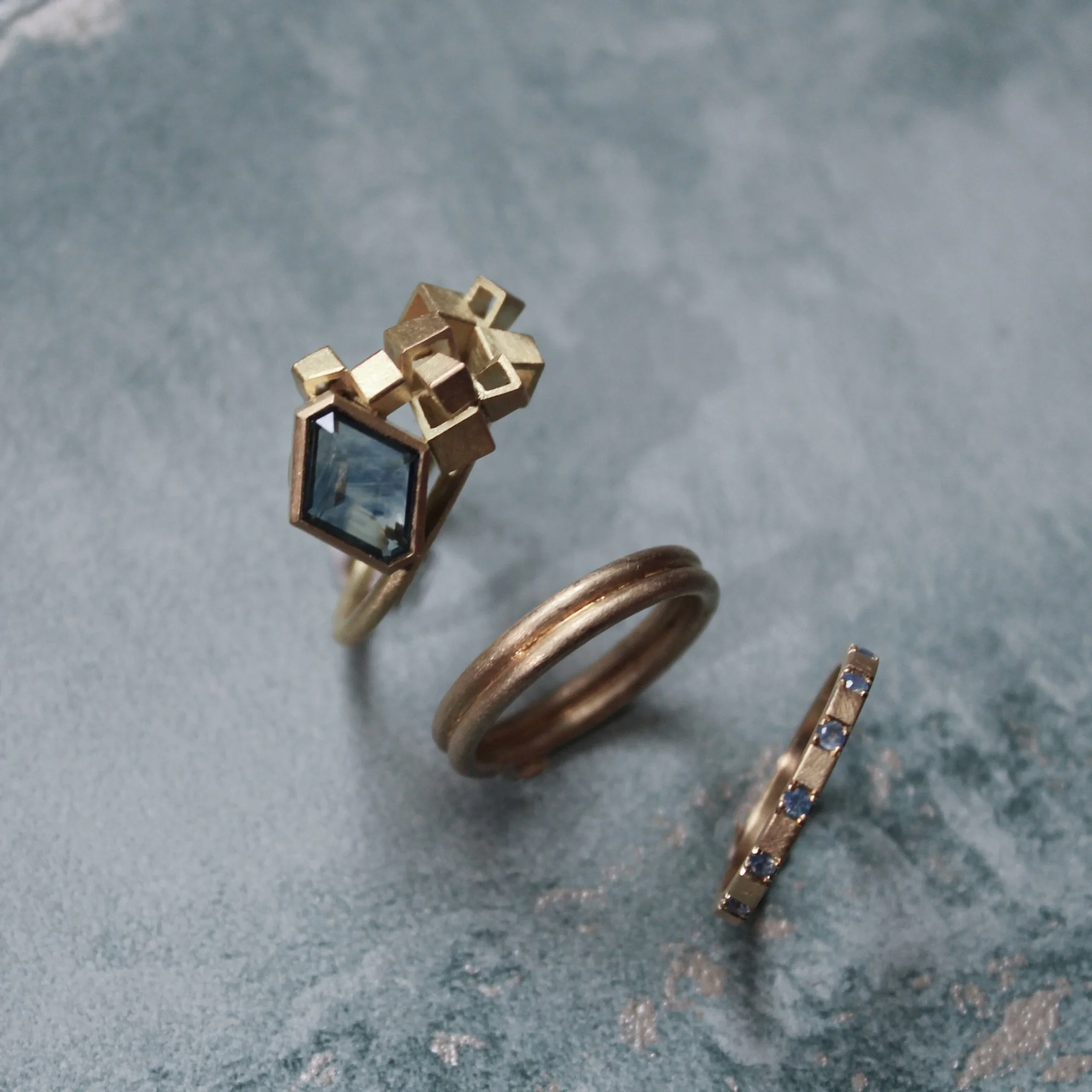 This delicious blue and gold stack features the Double Banded Lines of Latitude ring, Sapphire Eternity ring II and the icon of the month - Kite Cluster Ring