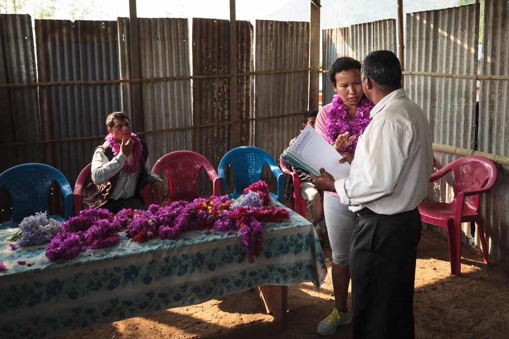 Rewati Gurung talks with one of the event organisers before distributing the school bags.