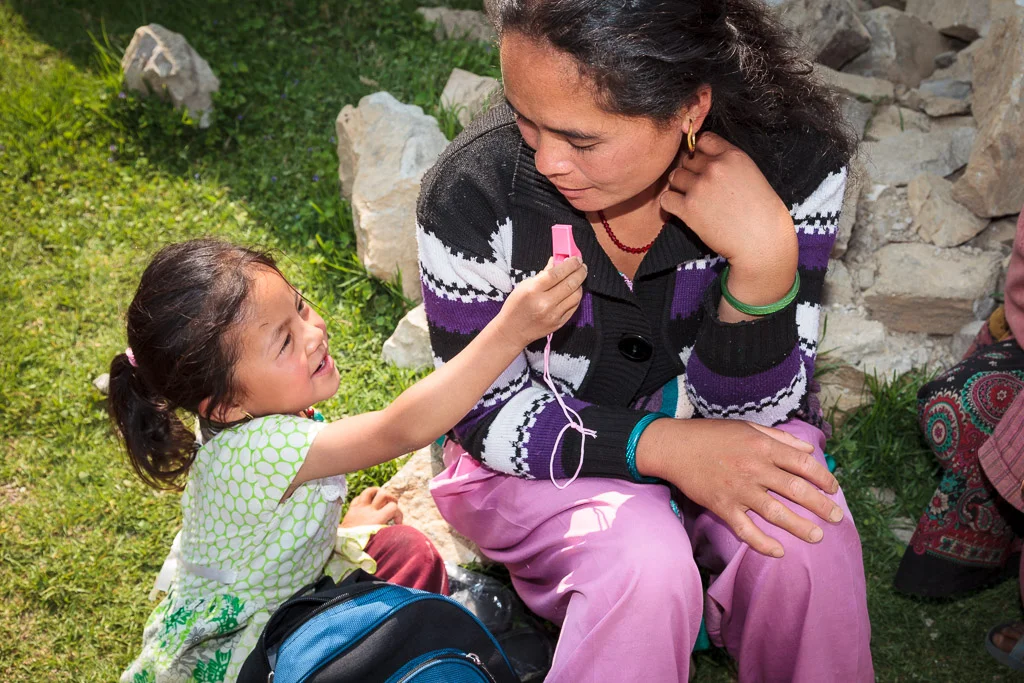 A young pupil shows her mum the pink whistle she got with her Moving Mountain School Bag at Shree Chippling Primary School in Sindupalchowk district.