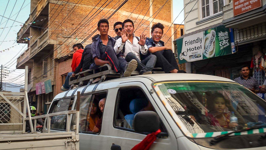 With the severe shortage of fuel in Nepal, local buses carry as many people as possible including using the luggage racks on top to carry passengers.