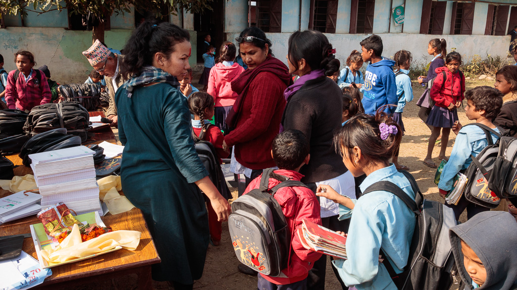 Rewati Gurung handing out school bags to the children in Dudhauli, Sindhuli. 