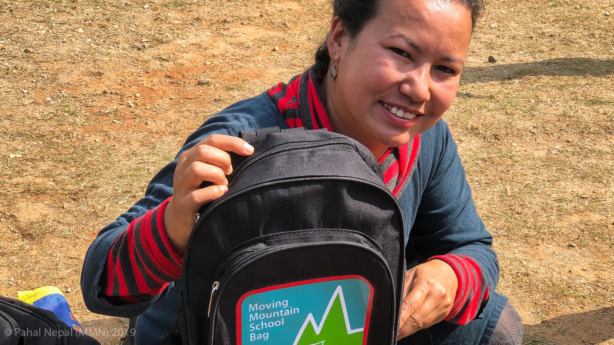 Rewati Gurung - founder of Moving Mountain Nepal shows the latest school bag. Since the early days the bag has been developed by our bag maker in Kathmandu to be robust and waterproof capable of lasting the student for many years.