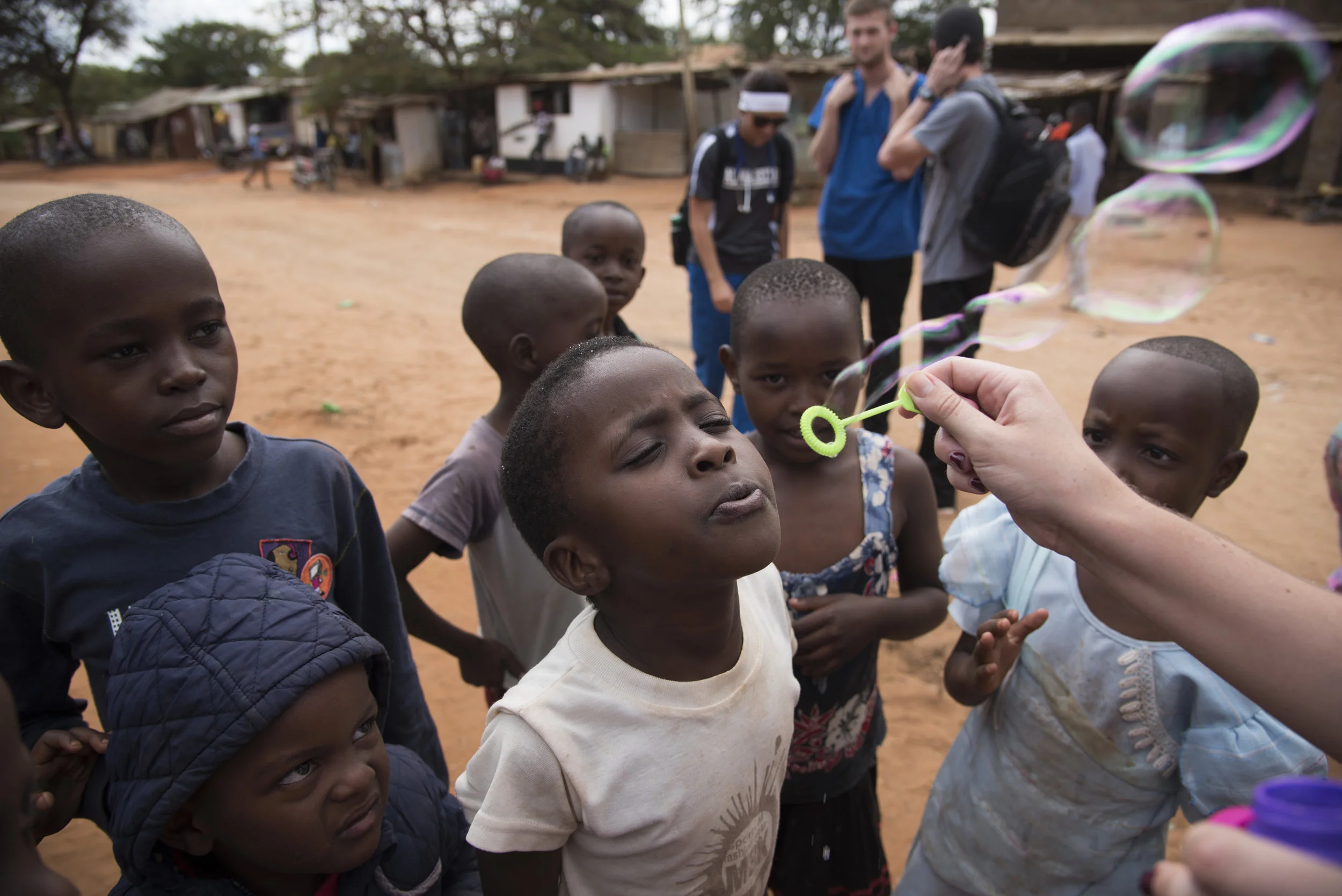  Children in the village of Kasigau, Kenya blow bubbles with the assistance of Western Kentucky University senior Katlyn Wathen, 21, while students are on a break from working in local medical clinics on June 4, 2016. 