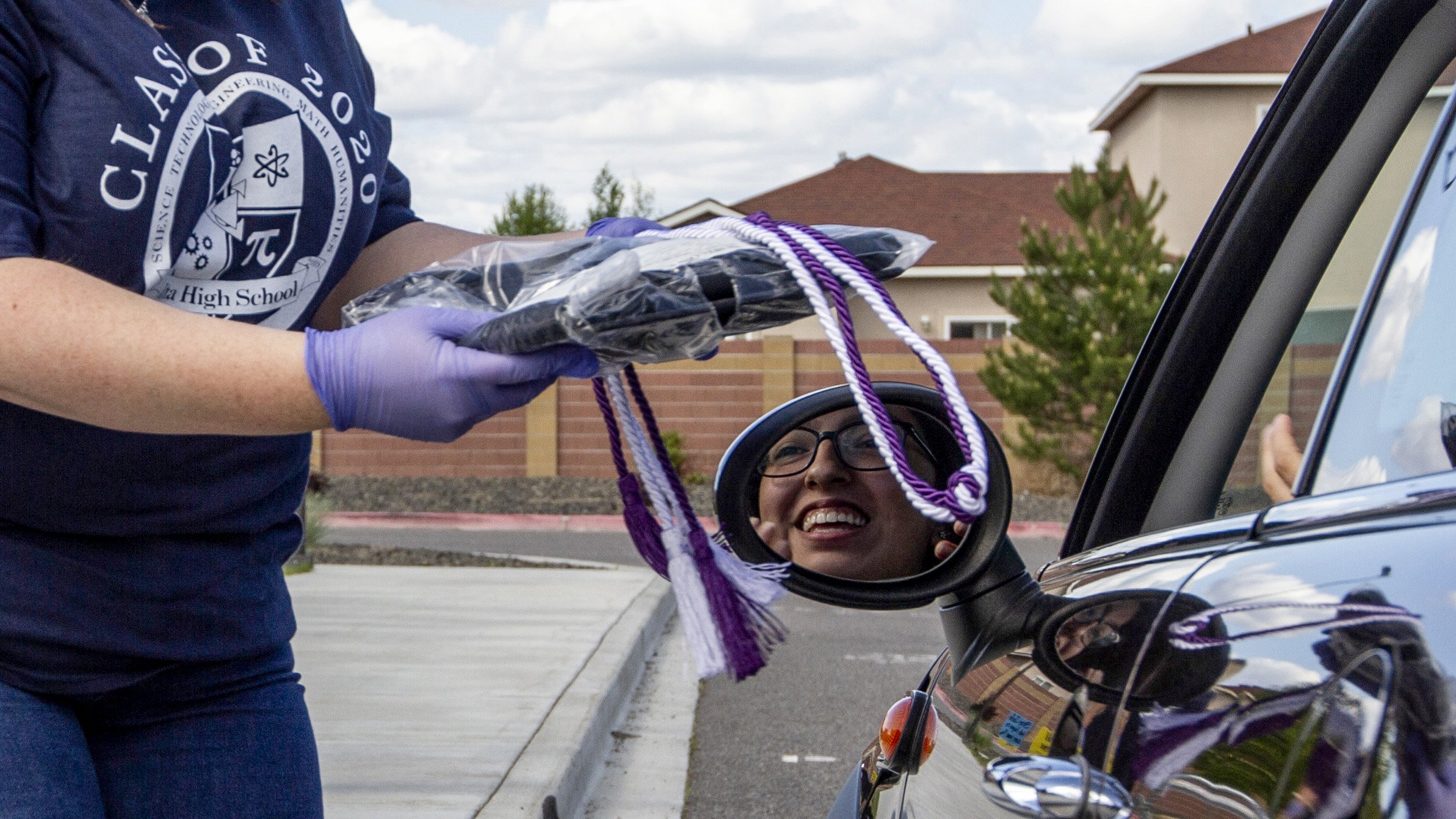  Seniors from Delta High School picked up their caps and gowns through a socially distanced drive-thru at the school’s campus in Pasco on April 23, 2020.  