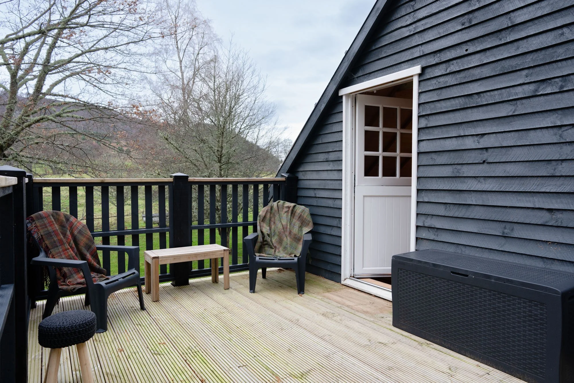 Private outdoor deck at The Hayloft with seating overlooking the surrounding trees and countryside.